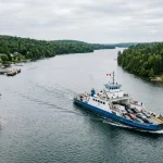 Un moderno traghetto Ro-Pax attraversa il Fiume St. Marys, collegando le sponde boscose, con veicoli e passeggeri a bordo. (Immagine generata con IA)