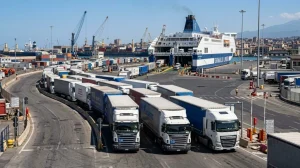 Traghetti e tir in un porto siciliano, simbolo del caro-carburanti e trasporti (Immagine generata con IA)